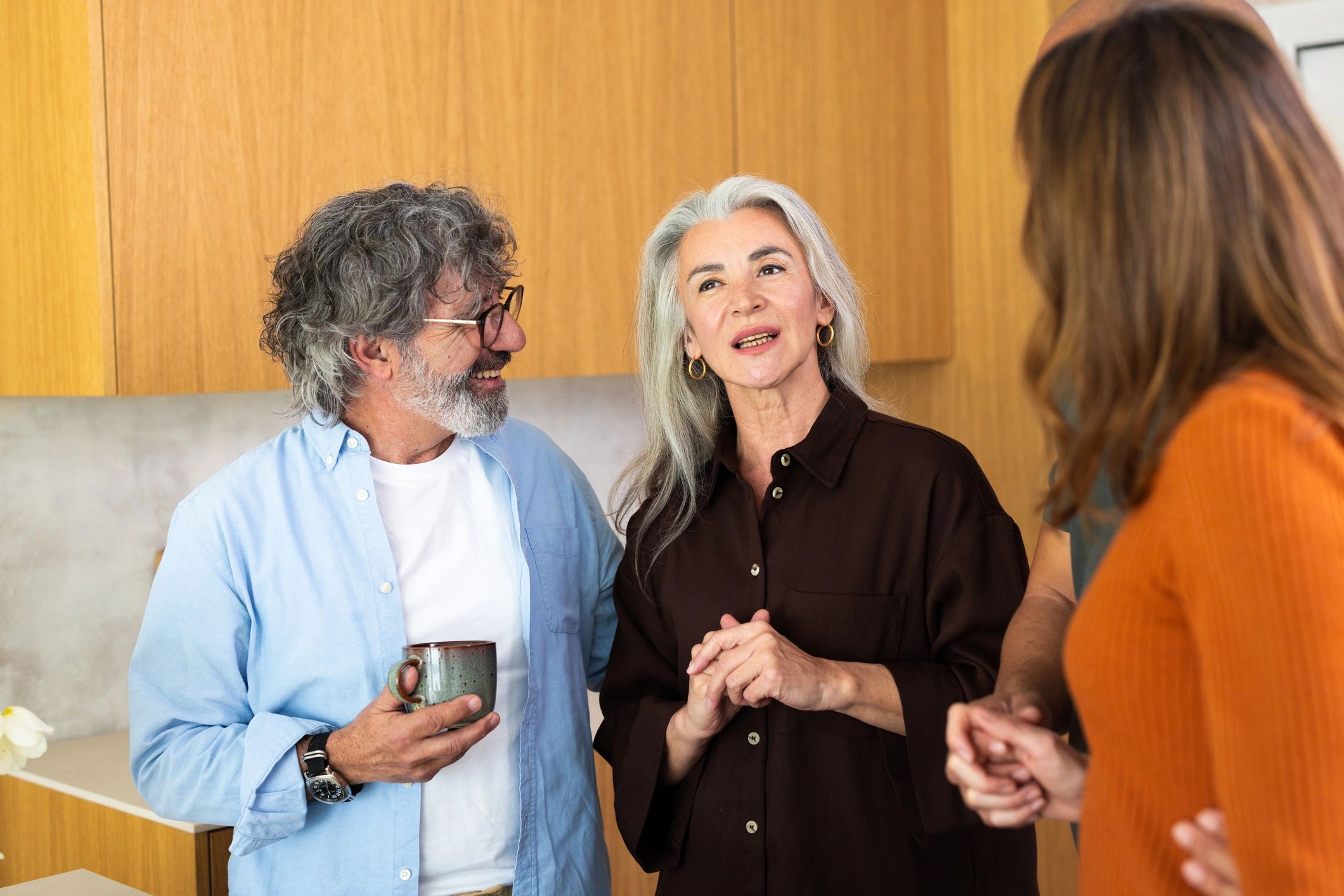 Mature adults engaging in a lively discussion during a home gathering